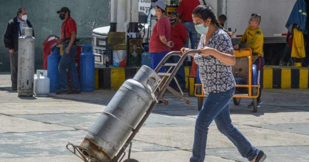 persona mujer cargando tanque gas